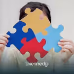 A kid is holding four puzzle pieces