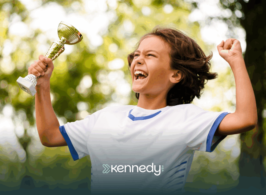A kid holding a trophy while happily jumping