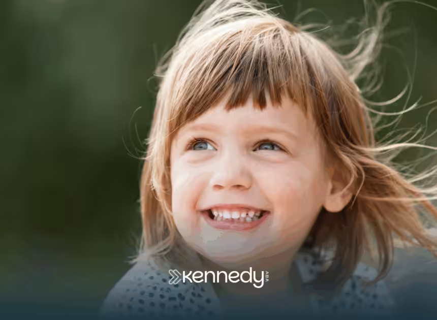 A kid with autism smiling outdoors