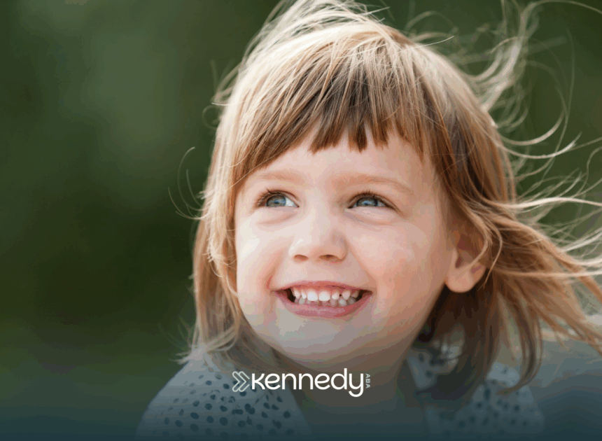 A kid with autism smiling outdoors