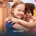 A girl with autism is hugging her friend in an outdoor playground