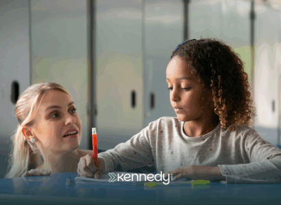 An RBT is helping a kid with autism write during ABA therapy