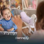A kid with autism is playing a keyboard with her RBT during ABA therapy