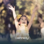A kid with autism happily raising her arms outdoors