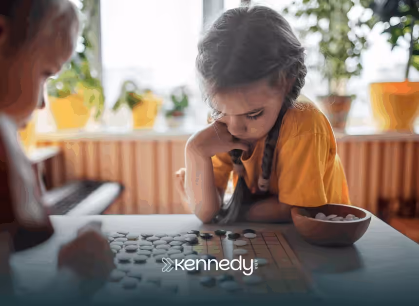 A kid is focused while playing a board game with her siblign