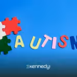 A cutout of the word "autism" and puzzle pieces on a blue background