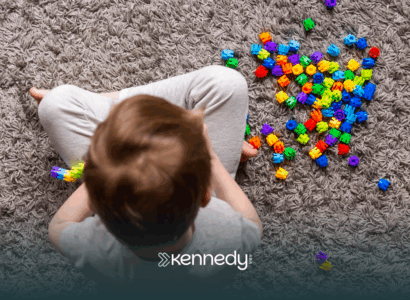 A kid sitting on a carpet, playing with colorful toys