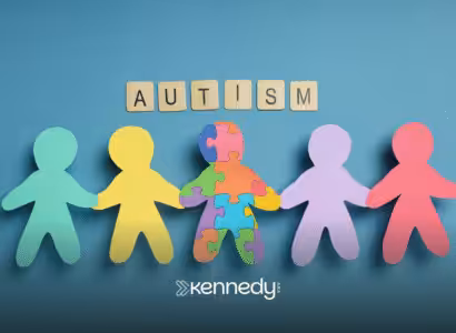 A cutout of colorful papers in human shape holding hands together with a cutout of paper squares that spells the word 'autism'