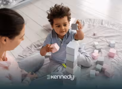 A child and an RBT playing with colorful blocks during ABA therapy