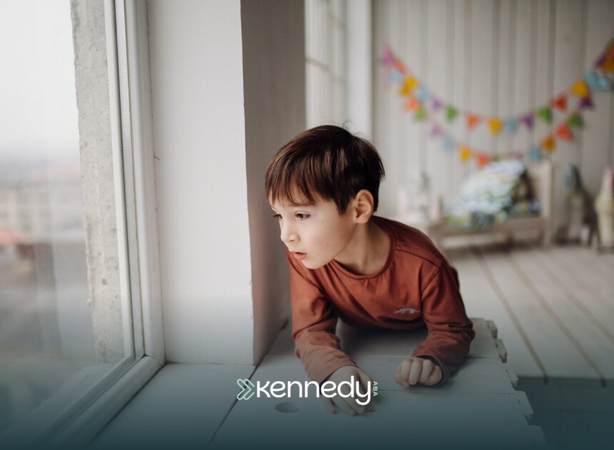 A kid with autism looking from a window alone