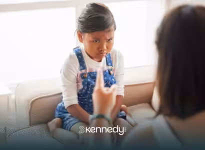 A kid with autism looking upset while being scolded