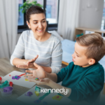 An RBT and a kid with autism sitting at a table during ABA therapy