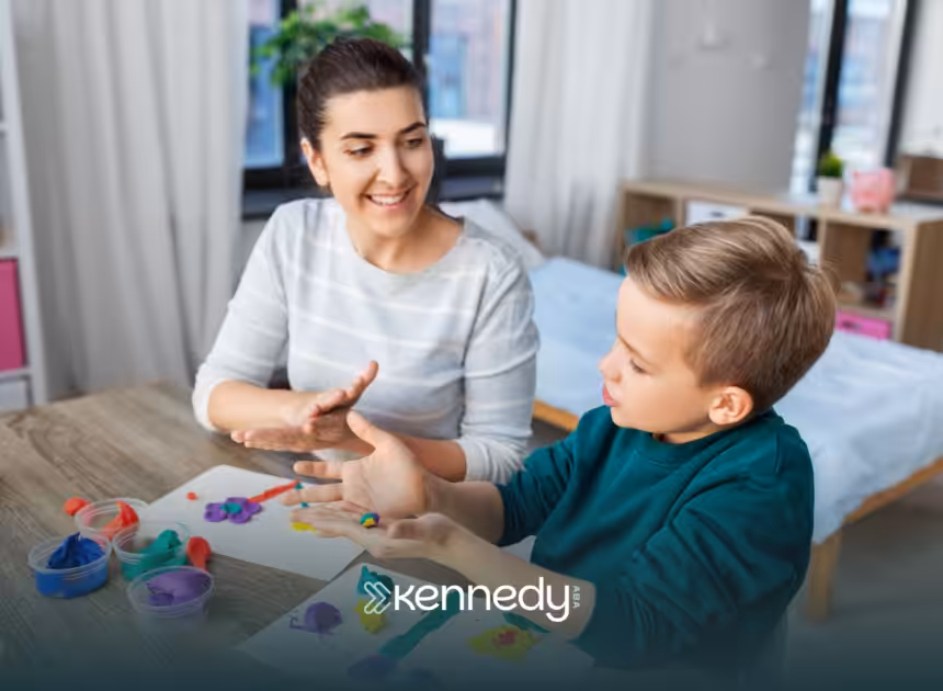 An RBT and a kid with autism sitting at a table during ABA therapy
