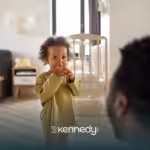 A kid standing in front of her parent in their living room