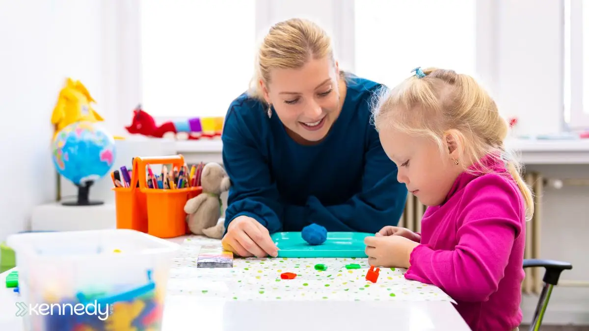 child-working-on-fine-motor-task-with-adult-guidance-in-classroom