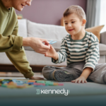 A kid with autism and his ABA therapist sitting on a floor during ABA therapy
