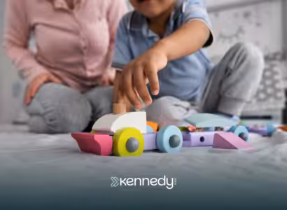 A kid and his ABA therapist playing with wooden toys during ABA therapy at home