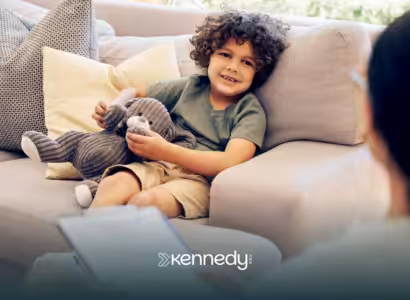 A child sitting on a couch listening to his ABA therapist