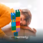 A tower of colorful toy blocks being looked at by a kid with autism