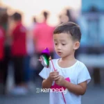 young-boy-holding-colorful-pinwheel-outdoors-in-public-space