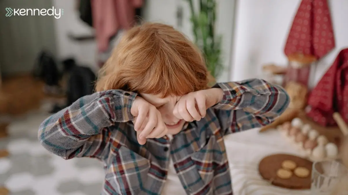 young-boy-rubbing-eyes-during-upset-moment-at-home