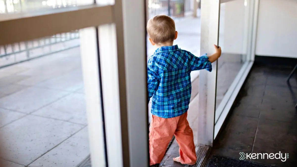 young-child-reaching-for-exit-door-in-indoor-public-space