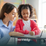 A kid with autism and an ABA therapist during school-based ABA therapy