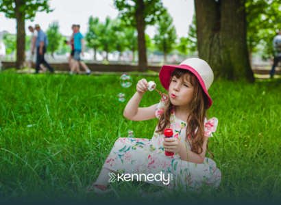 A girl with autism blowing bubbles in a park