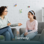 A kid with autism talking to an RBT during ABA therapy