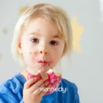 young-girl-eating-pink-frosted-donut