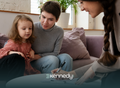 A mother with her child with autism talking to an ABA therapist