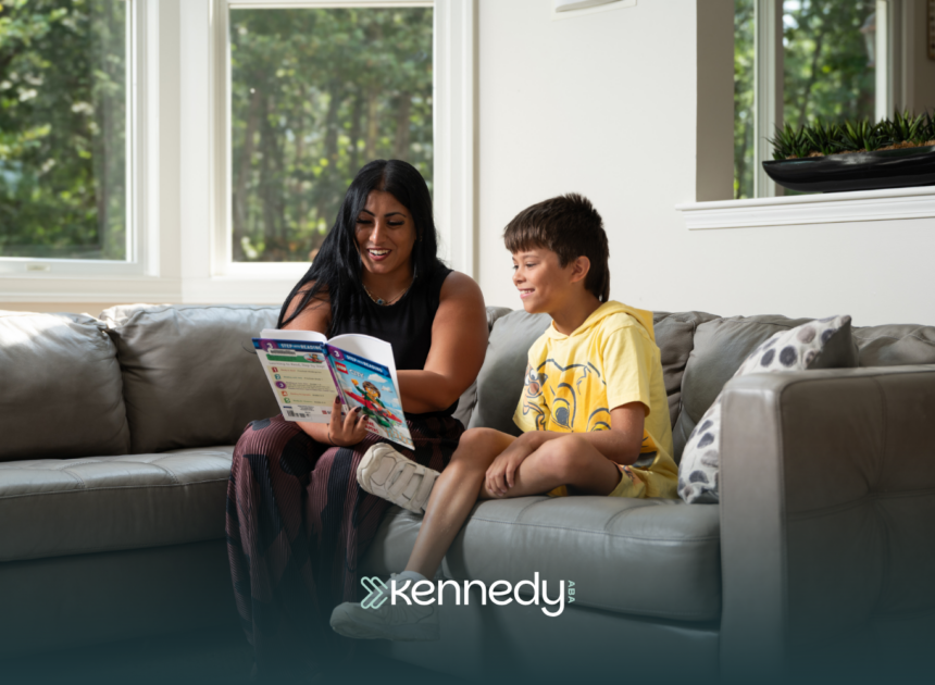 A kid with autism and his ABA therapist reading a book together on a couch during ABA therapy