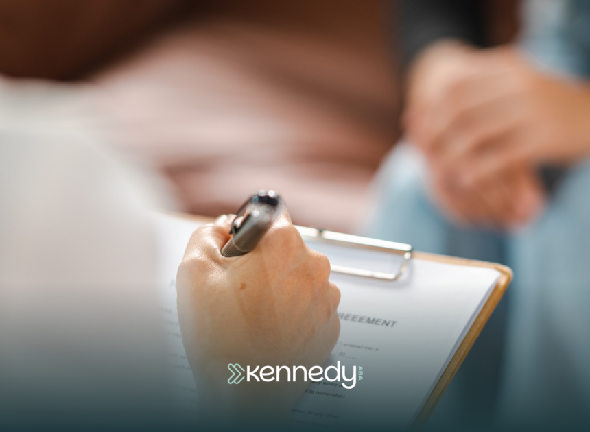An ABA therapist writing on a clipboard