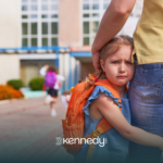 A kid hugging her parent's legs, refusing to go to school