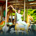 A child in a theme park, riding a merry-go-round