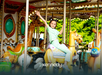 A child in a theme park, riding a merry-go-round