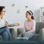 A kid with autism and an ABA therapist talking during ABA therapy