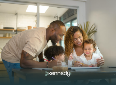A family of four sitting at a dining table together looking at autism grants