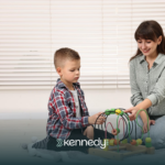 A kid with autism and an ABA therapist talking during ABA therapy