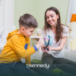 A BCBA talking to a boy during ABA therapy