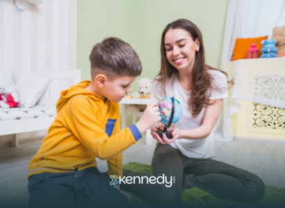 A BCBA talking to a boy during ABA therapy