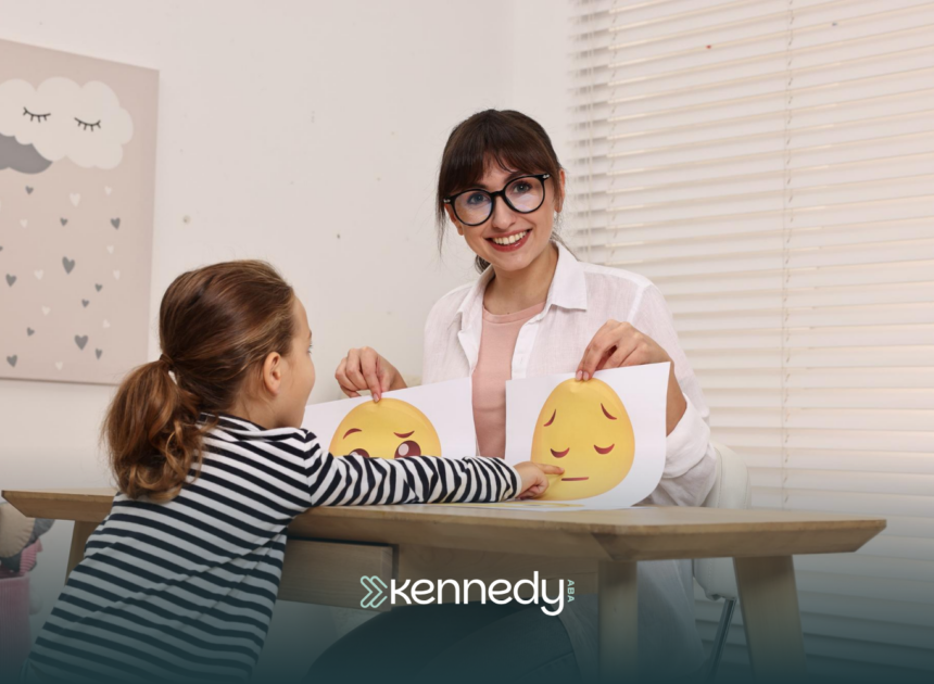 An ABA therapist showing printed smileys to a kid during ABA therapy