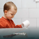 A kid with autism holding a roll of tissue, during toilet training