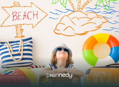 A kid ready for summer, with summer goals behind him written on a wall