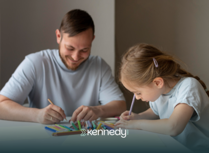 A kid with autism and her father boding together doing arts on a table