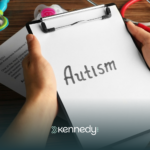 A clipboard with the word 'autism' being held by a person