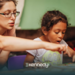 A kid with autism and her mother doing an activity at home
