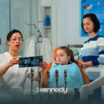 A kid with autism sitting on a dental chair during a dental checkup with her mother behind her