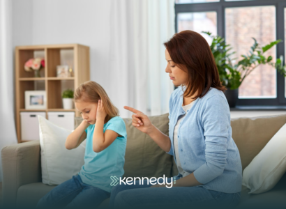 A kid covering her ears, throwing a tantrum, while her ABA therapist comfort her