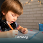 A kid writing on a paper at a table